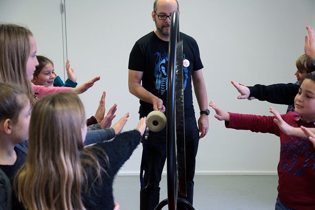 Betreuer in der Mitmach-Ausstellung präsentiert den Gong.