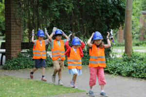 Performance in Baustellen-Kleidung. Kindergruppe im Park.